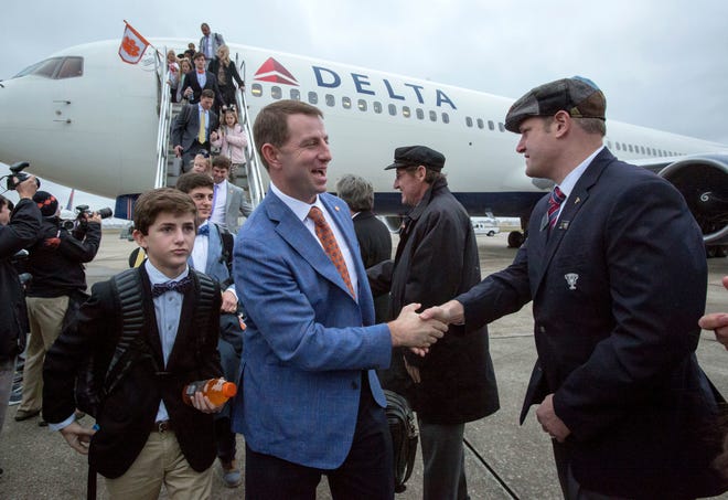 Clemson coach Dabo Swinney, front left, and players are welcomed at Louis Armstrong New Orleans International Airport on Wednesday in Kenner, La. Clemson plays Alabama in the Sugar Bowl on Monday. [SCOTT THRELKELD/The Advocate via AP]