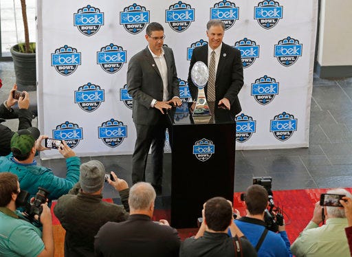 Wake Forest head coach Dave Clawson, right, and Texas A&M interim head coach Jeff Banks, left, pose with the trophy during media day for the Belk Bowl NCAA college football game in Charlotte, N.C., Thursday, Dec. 28, 2017. (AP Photo/Chuck Burton)