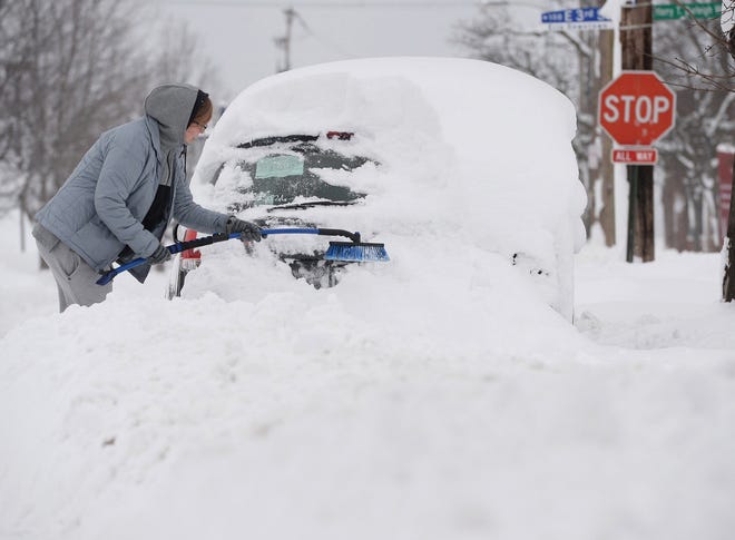 Chelse Volgyes clears snow from her car in Erie, Pa., on Wednesday. Freezing temperatures and below-zero wind chills socked much of the northern United States on Wednesday and Thursday. [Erie Times-News via AP / Jack Hanrahan]