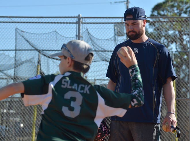 Logan Allen, an IMG Academy graduate now pitching in the San Diego Padres minor league system, works with participants in the 2017 Holiday Baseball Clinic Thursday at Chuck Reiter Park in Venice. [HERALD-TRIBUNE STAFF PHOTO / MIKE LANG]
