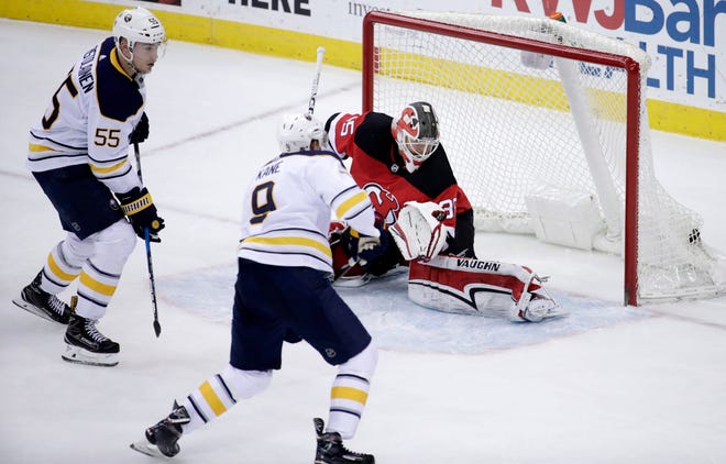 Buffalo Sabres defenseman Rasmus Ristolainen (55), of Finland, watches his game-winning shot enter the net of New Jersey Devils goalie Cory Schneider (35) during overtime of an NHL hockey game, Friday, Dec. 29, 2017, in Newark, N.J. Sabres' Evander Kane (9) looks on during the play. The Devils won 4-3 in overtime. (AP Photo/Julio Cortez)