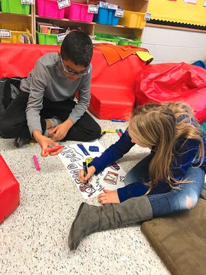 Submitted photo - Andre Moquette, left, and Charlize Schaffer, fifth-graders at Fredon Township School, work on posters for a Thanksgiving food drive.