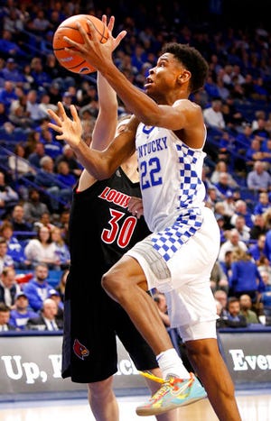 Kentucky's Shai Gilgeous-Alexander (22) shoots while defended by Louisville's Ryan McMahon (30) during the second half of an NCAA college basketball game, Friday, Dec. 29, 2017, in Lexington, Ky. Kentucky won 90-61. (AP Photo/James Crisp)