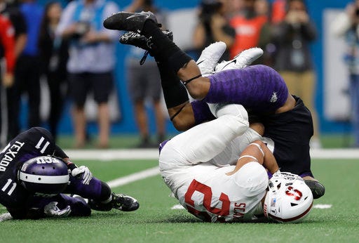 Stanford running back Cameron Scarlett (22) is dropped by TCU safety Innis Gaines, right, after a run during the second half of the Alamo Bowl NCAA college football game, Thursday, Dec. 28, 2017, in San Antonio. (AP Photo/Eric Gay)