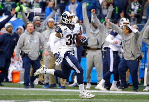 FILE - In this Sunday, Dec. 17, 2017, file photo, Los Angeles Rams running back Todd Gurley runs for his third touchdown in the first half of an NFL football game against the Seattle Seahawks, in Seattle. Gurley realizes he could lose his first NFL rushing title, and maybe even the league MVP award, while he stands on the sidelines at the Coliseum during the regular season finale, Sunday, Dec. 31. (AP Photo/Elaine Thompson, File)