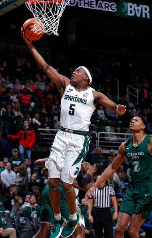 Michigan State's Cassius Winston (5) shoots a layup in front of Cleveland State's Anthony Wright (2) during the first half of an NCAA college basketball game Friday, Dec. 29, 2017, in East Lansing, Mich. (AP Photo/Al Goldis)