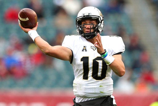 FILE - In this Saturday, Nov. 18, 2017, file photo, Central Florida quarterback McKenzie Milton (10) attempts a pass against Temple during the first quarter in an NCAA college football game in Philadelphia. Central Florida coach Scott Frost and nine of his assistants will be full-time Nebraska employees immediately after the Peach Bowl game against Auburn on Monday, Jan. 1, 2018. Until then, they’ve worked almost nonstop to make sure the Central Florida players feel no disruption in their normal practice-day schedules. Milton knows that hasn’t been easy. (AP Photo/Rich Schultz, File)