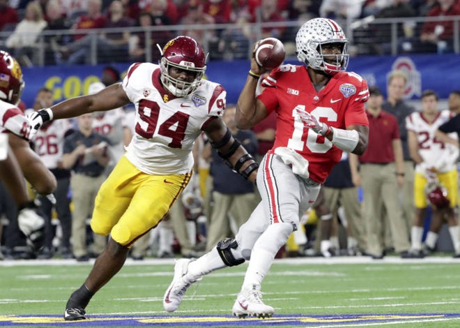 Ohio State quarterback J.T. Barrett (16) is chased by Southern California defensive tackle Rasheem Green (94) during the first half of the Cotton Bowl NCAA college football game in Arlington, Texas, Friday, Dec. 29, 2017. (AP Photo/LM Otero)