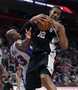 San Antonio Spurs forward LaMarcus Aldridge (12) pulls down a rebound next to Detroit Pistons forward Anthony Tolliver (43) during the first half of a game, Saturday, in Detroit. (AP Photo/Carlos Osorio)