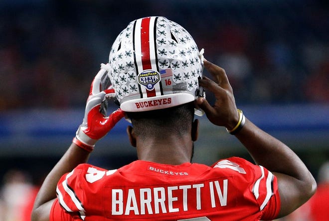 Ohio State Buckeyes quarterback J.T. Barrett (16) puts his helmet on during pregame drills before the Goodyear Cotton Bowl Classic. File photo