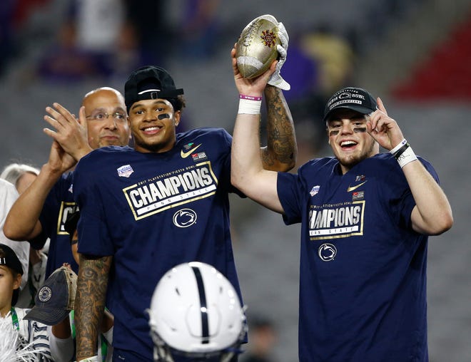 Offensive player of the game, Penn State quarterback Trace McSorley, right, and defensive player of the game, safety Marcus Allen, hold the champions trophy after the Fiesta Bowl NCAA college football game against Washington, Saturday, Dec. 30, 2017, in Glendale, Ariz. Penn State won 35-28. (AP Photo/Ross D. Franklin)