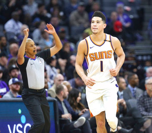 Phoenix Suns guard Devin Booker (1) reacts after hitting a three-point shot during the first half of an NBA basketball game against the Sacramento Kings in Sacramento, Calif., Friday, Dec. 29, 2017. (AP Photo/Steve Yeater)