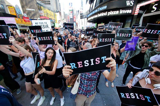FILE - In a Wednesday, July 26, 2017 file photo, demonstrators gather in Times Square, in New York to protest after President Donald Trump declared a ban on transgender troops serving anywhere in the U.S. military. The Justice Department has put its proposed ban on transgender military recruits on hold, meaning their enlistment can start Monday, Jan. 1, 2017. But the future for transgender people in the armed forces remains murky. (AP Photo/Frank Franklin II, File)