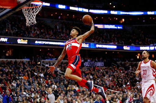Washington Wizards forward Kelly Oubre Jr. (12) goes for a dunk past Houston Rockets forward Ryan Anderson (33) during the second half of an NBA basketball game Friday, Dec. 29, 2017, in Washington. The Wizards won 121-103. (AP Photo/Alex Brandon)