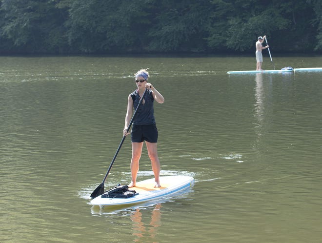 Lauren Johnson of Economy, a student at the Sangha Center for Yoga and Wellness in Beaver, oversees a paddle boarding exhibition run by the Sangha Center, at the 2015 Gear and Cheer Music Festival at Bradys Run Park.