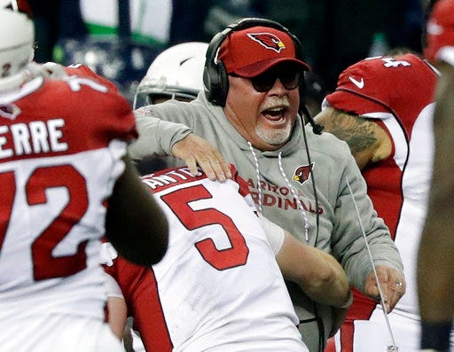 Arizona Cardinals head coach Bruce Arians is hugged by quarterback Drew Stanton (5) after Seattle Seahawks kicker Blair Walsh missed a field goal at the end of an NFL football game, Sunday, Dec. 31, 2017, in Seattle. (AP Photo/Elaine Thompson)