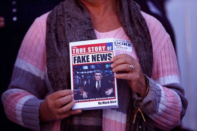 In a Nov. 17 file photo, a supporter holds up a "Fake News" book while Kayla Moore, wife of U.S. Senate candidate Roy Moore, speaks at a press conference in Montgomery, Ala. Would a story that seeks to unpack or drill down on a list of tiresome words and phrases be impactful or a nothingburger? Worse, would it just be tons of fake news? Well, dish all you want, but Northern Michigan's Lake Superior State University on Sunday released its 43rd annual List of Words Banished from the Queen's English for Misuse, Overuse and General Uselessness.