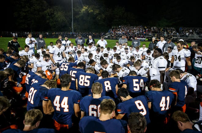 Sacred Heart-Griffin's John Keen (44) leads a prayer with the Cyclones and the Rochester Rockets for Liz Leonard, the mother Rochester's Derek Leonard and the wife of Sacred Heart-Griffin's Ken Leonard prior to kickoff at Rocket Booster Stadium, Friday, Oct. 6, 2017, in Rochester. Liz Leonard died Sunday morning from cancer. [Justin L. Fowler/The State Journal-Register]