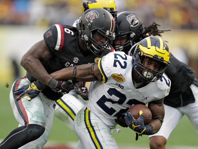 Michigan running back Karan Higdon (22) is stopped by South Carolina linebacker T.J. Brunson (6) during the second half of the Outback Bowl on Monday in Tampa. (Associated Press/Chris O'Meara)