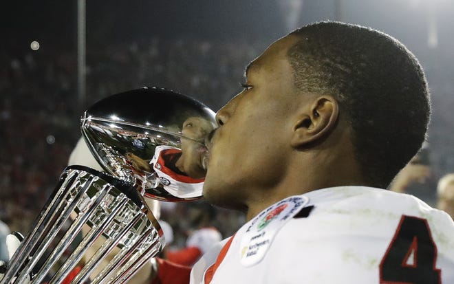 Georgia wide receiver Mecole Hardman kisses the trophy after Georgia beat Oklahoma 54-48 in overtime in the Rose Bowl NCAA college football game, Monday, Jan. 1, 2018, in Pasadena, Calif. (AP Photo/Gregory Bull)