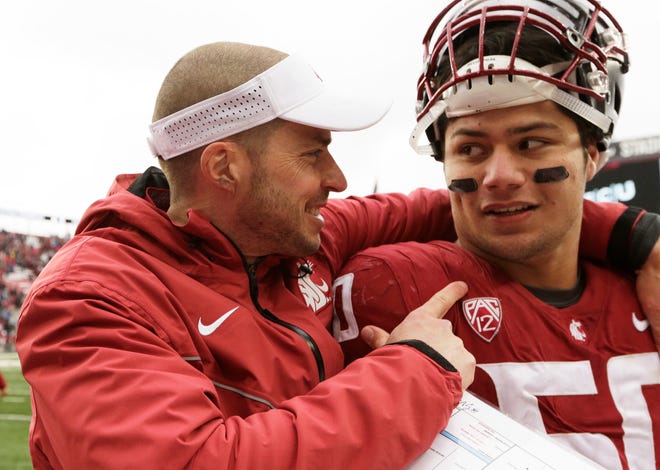 Washington State defensive coordinator Alex Grinch, left, talks with Hercules Mata'afa (50) earlier this season. Grinch is expected to join Urban Meyer's staff at Ohio State on Jan. 9