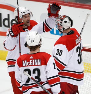 Carolina Hurricanes goaltender Cam Ward (30) celebrates with Justin Williams (14) and Brock McGinn (23) after shutting out the Pittsburgh Penguins 4-0 in an NHL hockey game in Pittsburgh, Thursday, Jan. 4, 2018. (AP Photo/Gene J. Puskar)