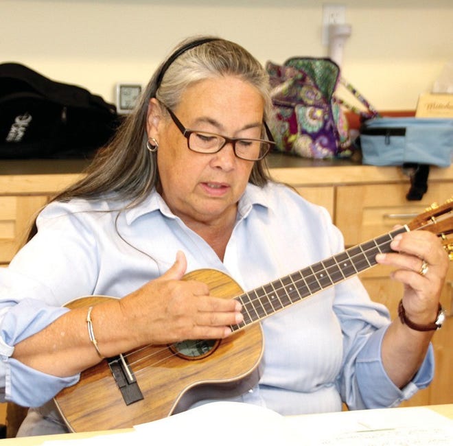 Deb Emmons tries out the ukelele. George Hoffman practices harmonica at the Sterling Senior Center. JOYCE ROBERTS PHOTOS