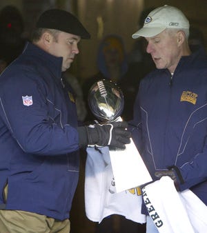 In this Feb. 8, 2011, photo, Green Bay Packers general manager Ted Thompson, right, hands the Vince Lombardi Trophy to coach Mike McCarthy before walking on to the field for the "Return to Titletown" celebration, at Lambeau Field in Green Bay, Wis. Ted Thompson is leaving his job as general manager of the Green Bay Packers, a big change after one of the league's most successful and stable teams missed the playoffs and finished with a losing record for the first time since 2008. The Packers (7-9) have not formally announced the move that surfaced in media reports on Monday, but players spoke about the transition as they cleaned out their lockers on Tuesday, Jan. 2, 2018. [MIKE ROEMER/THE ASSOCIATED PRESS]
