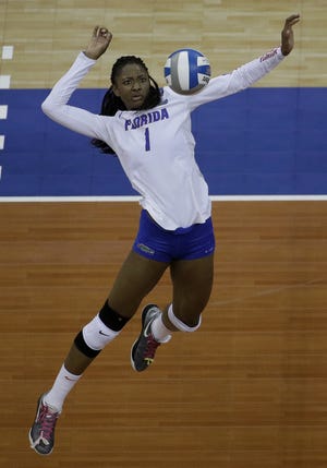 Florida middle blocker Rhamat Alhassan goes up for a kill during the NCAA Division I volleyball semifinal game against Stanford last month in Kansas City, Mo. Alhassan was recognized this week as the sport's top collegiate player for 2017. [Charlie Riedel/Associated Press]