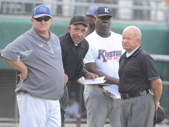 Kinston Post 43 American Legion baseball coach Ronnie Battle, second from right, talks to Wilson Post 13 coach Rusty Dail and umpires during a game at Grainger Stadium in 2015. Battle died Friday after a fight with cancer. [Janet S. Carter/The Free Press] 



meet with umpires while a player uniform issue is discussed on June 29, 2015 at Grainger Stadium.