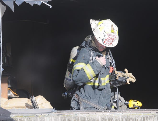 Canandaigua firefighter Don Phillips uses his portable to communicate a reading with a hand-held gas meter at the scene of a structure fire at Camelot Square Apartments on a brutally cold Saturday afternoon. A woman in a wheelchair was pulled from the apartment.

[Jack Haley/Messenger Post Media]