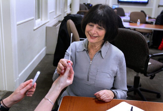 Sandra Robinson Gandsman of Pawtucket takes a cheek swab from an Alzheimer's researcher during a "swabbing party" at Butler Hospital in Providence recently. Gandsman is among the volunteers participating in a new Alzheimer's study led by Dr. Stephen Salloway, of Butler Hospital and the Warren Alpert Medical School of Brown University. The study seeks men and women age 60 to 75 who are cognitively normal but may be at risk — and are willing to share genetic information that can reveal if they are at high risk for the disease. Getting that info begins with a swab of the cheek. For videos and a podcast on the research, go to providencejournal.com/video [The Providence Journal / Kris Craig]