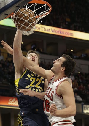 Indiana Pacers forward T.J. Leaf, left, dunks over Chicago Bulls forward Paul Zipser during the second half of the game in Indianapolis, Saturday, Jan. 6, 2018. The Pacers won 125-86. [AJ MAST/THE ASSOCIATED PRESS]