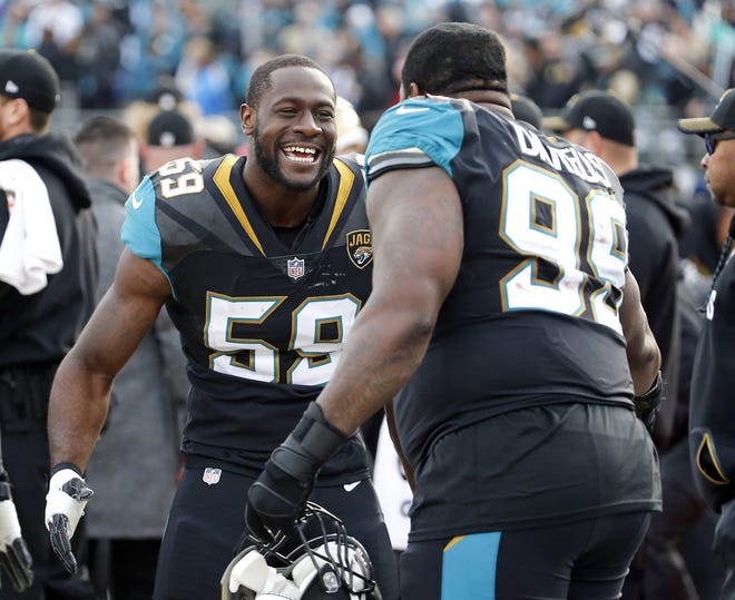 Jacksonville Jaguars defensive end Carroll Phillips (59) and defensive tackle Marcell Dareus (99) celebrate during the final moments of an NFL wild-card playoff football game against the Buffalo Bills, Sunday, Jan. 7, 2018, in Jacksonville, Fla. (AP Photo/Stephen B. Morton)