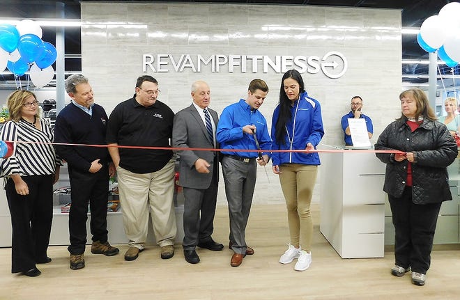 Revamp Fitness, at 127 E. Albany St., Herkimer, opened for business Monday, with a ribbon cutting hosted by the Herkimer County Chamber of Commerce. Pictured in center is Jason Crippen, owner, holding the pair of scissors, with Lisa Jordan, manager, pictured on the right. [STEPHANIE SORRELL-WHITE/TIMES TELEGRAM]