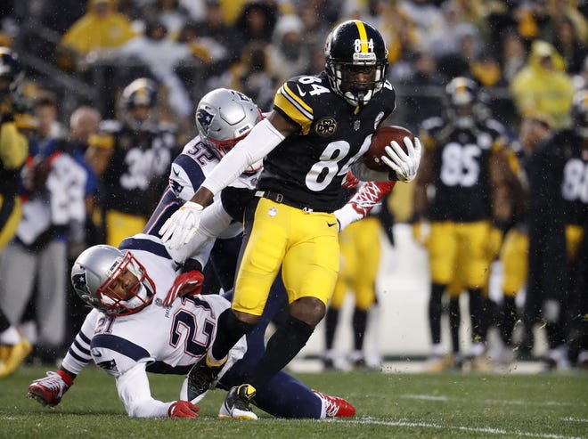 Pittsburgh Steelers wide receiver Antonio Brown escapes New England Patriots defenders during a NFL game at Heinz Field in Pittsburgh. [Winslow Townson/AP Images for Panini]