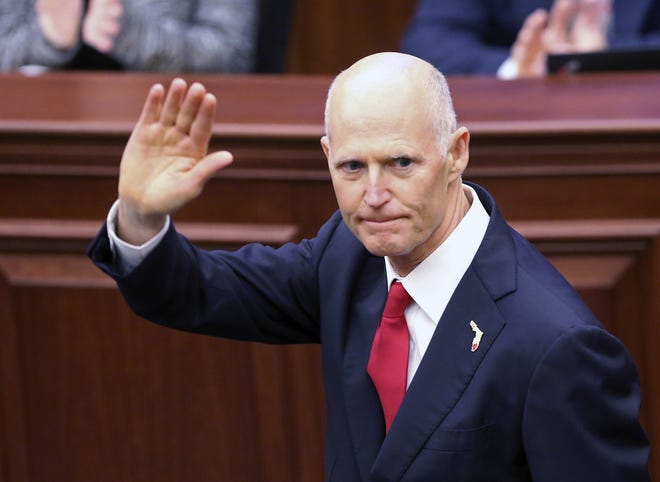 Gov. Rick Scott waves as he is introduced to the Senate on the first day of legislative session on Tuesday in Tallahassee. [Steve Cannon/AP]