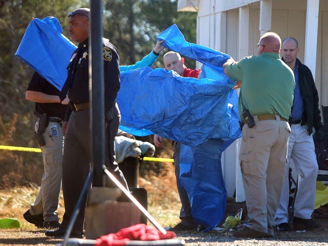 A tarp is brought out to cover the body of Calvin Walton after being involved in a shooting on Gantts Grove Church Road near Mooresboro on Tuesday. [Brittany Randolph/The Star]