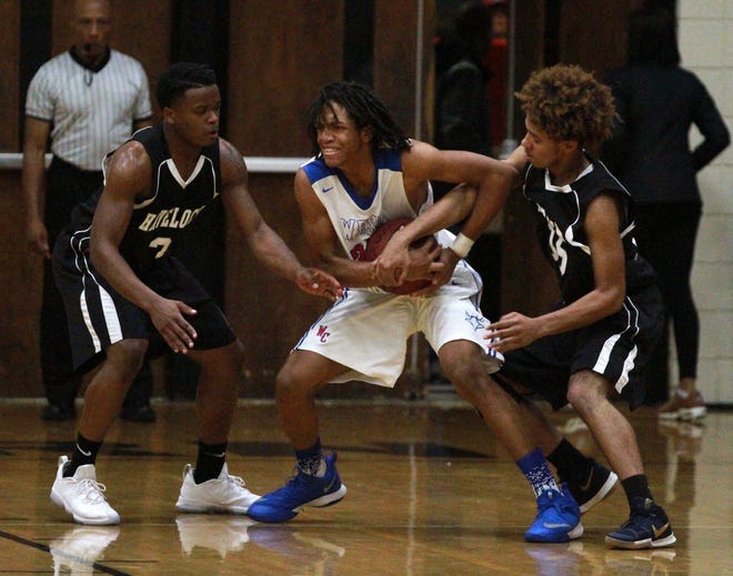 West Craven's Sheldon Yates (in white) tries to wrestle the basketball away from Havelock's Khalil Barrett (left in black) and Khari Knight in a game in the Craven County Holiday Hoops Classic in December. Area teams have not played or practiced in a week due to inclement weather. [Gray Whitley / Sun Journal Staff]