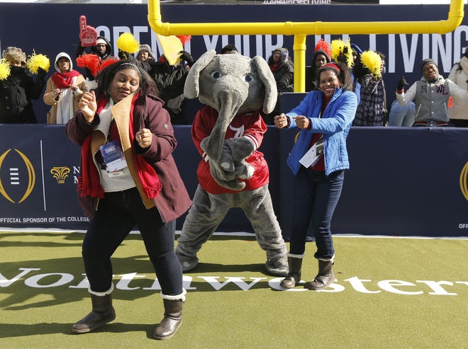 Alabama fans Asante Guilford, left, and her sister Che Guilford dance with Big Al as they do a touchdown celebration at Fan Central. Alabama and Georgia fans enjoyed activities at the Georgia World Congress Center Sunday, Jan. 7, 2018. [Staff Photo/Gary Cosby Jr.]
