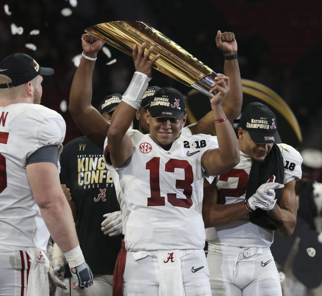 Alabama quarterback Tua Tagovailoa (13) hoists the National Championship trophy up as the Tide celebrates their victory over Georgia in overtime of the College Football Playoff National Championship game at Mercedes-Benz Stadium in Atlanta, Ga. on Monday, Jan. 8, 2018.  [Staff Photo/Erin Nelson]