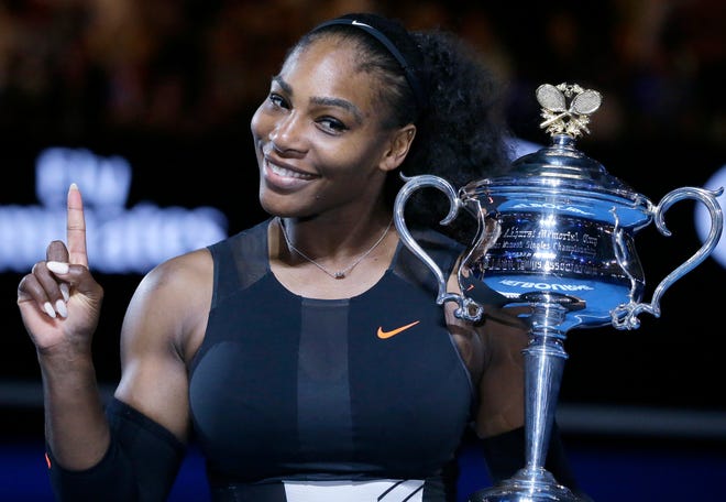 Serena Williams holds up a finger and her trophy after defeating her sister, Venus, in the women's singles final at the 2017 Australian Open championships in Melbourne, Australia. (AP Photo/Aaron Favila, File)