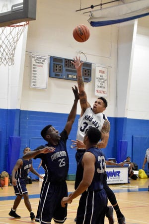 AO2 Robert Segarra, of the Naval Munitions Command, soars over his opponents to score for the Naval Air Station Flyers in their 79-71 double overtime win over Hurlburt Field Jan. 6. Segarra scored 16 points for the Flyers in the home game victory.