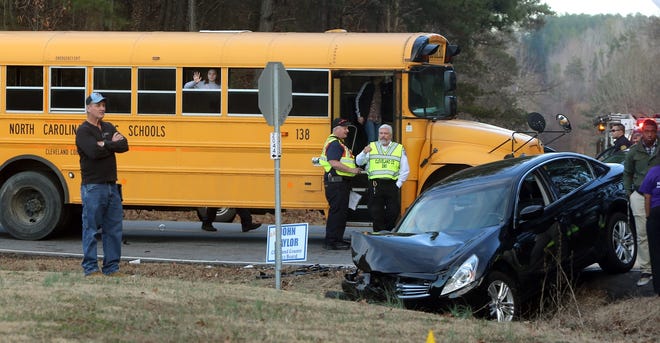 A student waves from a bus that was involved in a wreck at the intersection of New Camp Creek Church Road and Oak Grove Road on Wednesday. [Brittany Randolph/The Star]