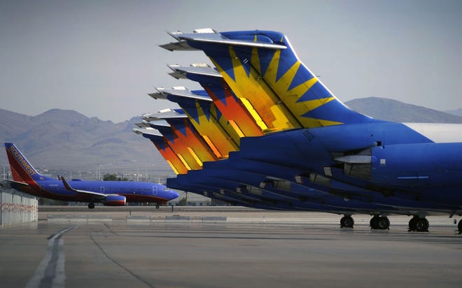 A Southwest airline taxis by parked Allegiant Air jetliners at McCarran International Airport in Las Vegas. While other U.S. airlines have struggled with the ups and downs of the economy and oil prices, tiny Allegiant Air has been profitable for 10 straight years. (AP Photo/David Becker)