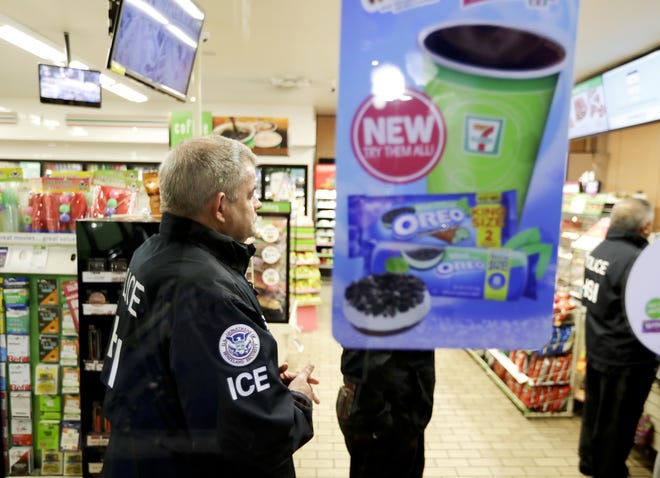 U.S. Immigration and Customs Enforcement agents serve an employment audit notice at a 7-Eleven convenience store Wednesday in Los Angeles. Agents said they targeted about 100 7-Eleven stores nationwide in check whether the stores had hired people in the country illegally.  [AP Photo / Chris Carlson]