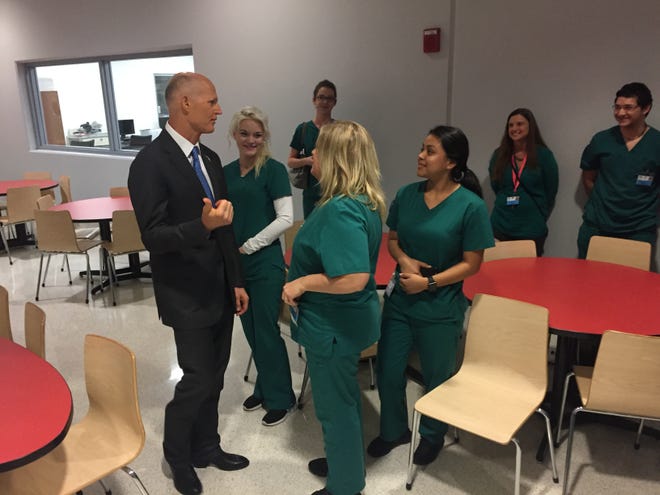 Florida Gov. Rick Scott speaks with optometric assisting students at Manatee Technical College on Wednesday during a tour of the campus. [Herald-Tribune photo / Ryan McKinnon]