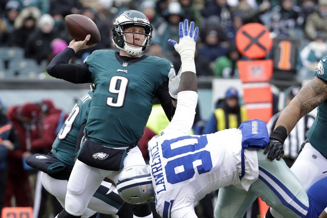 Philadelphia Eagles quarterback Nick Foles passes over the Dallas Cowboys' DeMarcus Lawrence (90) during the first half of a game Dec. 31 in Philadelphia. [The Associated Press / Chris Szagola]