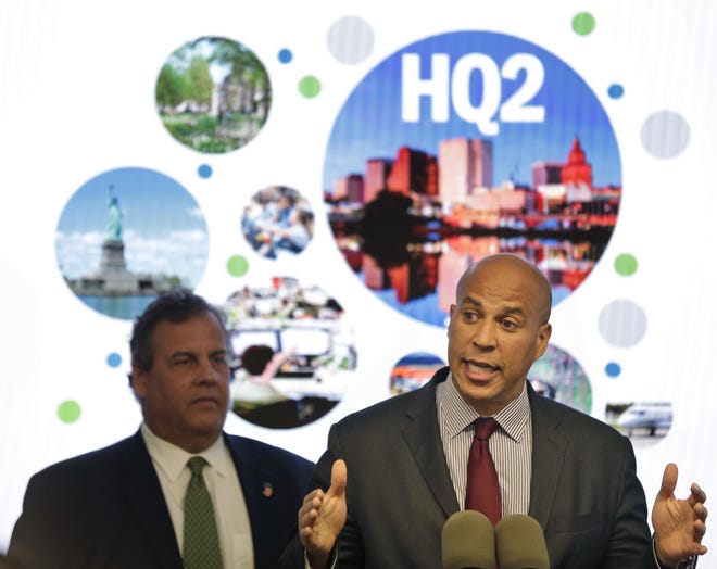 New Jersey Sen. Cory Booker speaks while Gov. Chris Christie stands behind him during an announcement in Newark. New Jersey lawmakers have signed off on $5 billion in tax breaks to Amazon in an effort to convince the company that Newark would be the best location for the company's planned second headquarters. [ASSOCIATED PRESS FILE PHOTO]