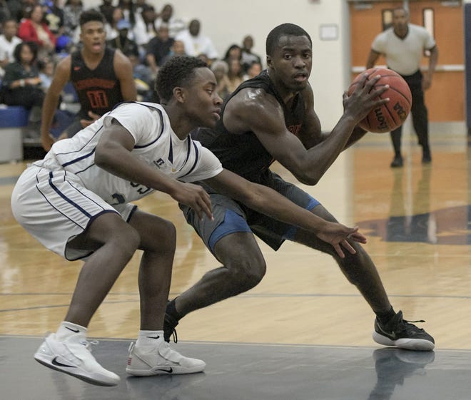 Leesburg's Cordrayius Graham (1) looks to get past Eustis' Thario Adkins (24) during Tuesday's game at Eustis High. A less-than-packed gym took some of the luster off the rivalry game. [PAUL RYAN /CORRESPONDENT]